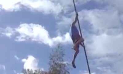 sportsman who climbs and breaks powerless electricity poles